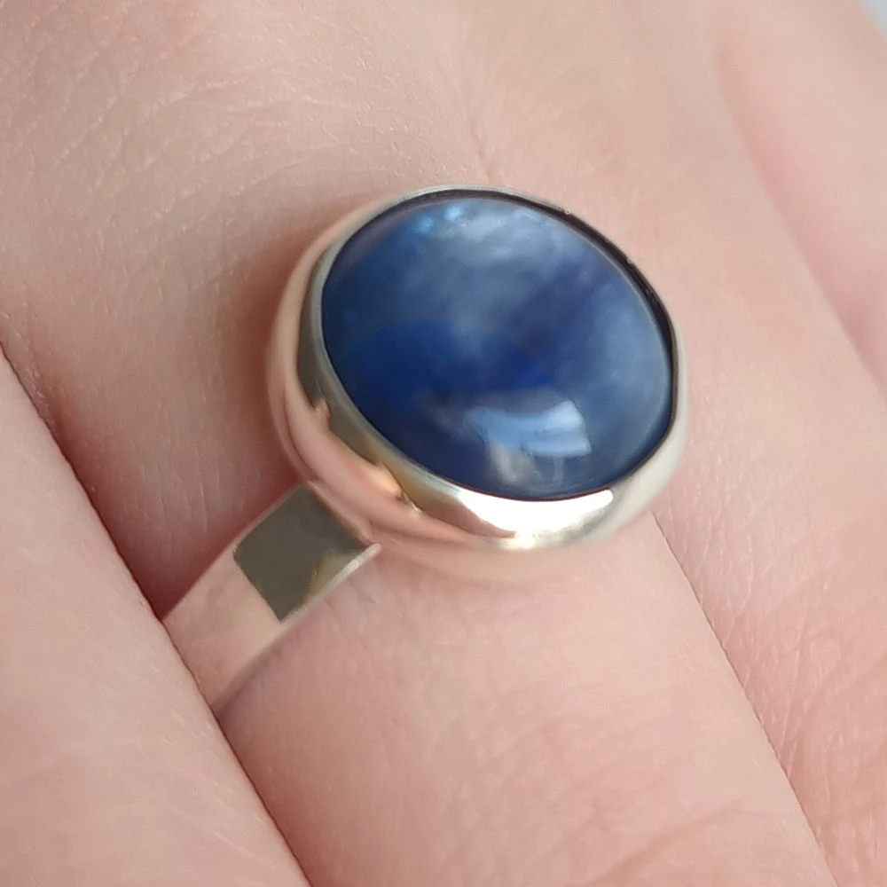 Anillo único hecho a mano de diseño minimalista con piedra natural Cianita Azul, montura en plata, en primer plano.